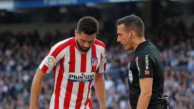 Atletico Madrid's Felipe watches as Real Madrid's Dani Carvajal grimaces in pain after sustaining an injury at the Santiago Bernabeu. Reuters