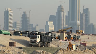 Lorries stand at a construction site across from skyscrapers in the budding new financial district in Doha. Qatar is heavily reliant on receiving construction materials through the Abu Samra border crossing. Sean Gallup/Getty Images