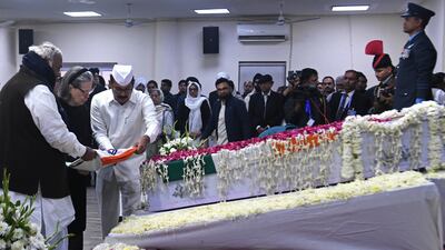 Indian National Congress president Mallikarjun Kharge, left, and chairwoman Sonia Gandhi place a flag on the casket of Mr Singh at their party headquarters in New Delhi. AP Photo