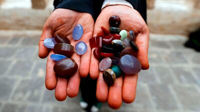 Safa al-Faqih, one of the few female Yemeni craftsmen working in the precious stones industry in Yemen, holds precious stones in the old city of the capital, Sanaa, on April 18, 2018. Due to the ongoing war in Yemen just a quarter of artisans are still working in Sanaa's old market, where the majority of gemstones were sold, and the men who previously dominated the industry have mostly gone in search of other work. Mohammed Huwais / AFP Photo