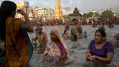 Indian devotees perform rituals as they take holy dips in the Godavari River