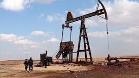 Syrian officers stand in front of one of the pumps at Al Omar oilfield. EPA