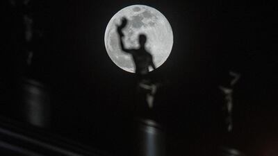 The moon rises behind a sculpture in Skopje. AFP