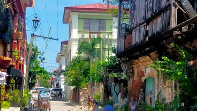 Residents clear up debris outside an old house in Vigan city, north of Manila. AFP