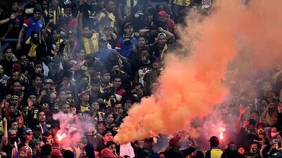 Malaysian football fans set off flares during their nation's 2018 World Cup qualifier against Saudi Arabia. Manan Vatsyayana / AFP