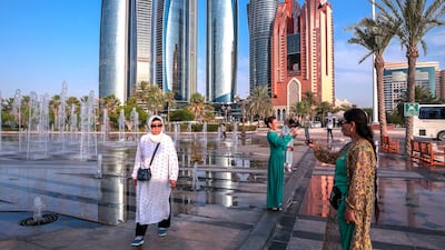 Visitors to the Emirates Palace Hotel fountain in Abu Dhabi take pictures. Photo: Victor Besa / The National