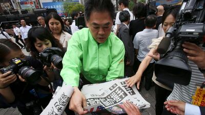 A staff member of a Japanese newspaper Yomiuri distributes an extra edition of the newspaper reporting about the summit at Shimbashi Station in Tokyo. Koji Sasahara / AP Photo