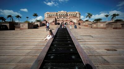 Tourists take photos at the entrance of the Emirates Palace Hotel in Abu Dhabi. Reuters
