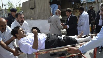 People carry an injured lawyer to a hospital following a bomb blast in Quetta, Pakistan. A powerful bomb went off on the grounds of a government-run hospital Monday, killing dozens of people, police said. Arshad Butt / AP