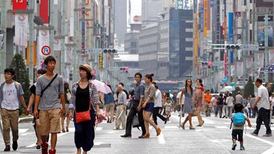 As Tokyo celebrates on Sunday, passersby are allowed to walk on Ginza street, which is closed off to traffic. Shuji Kajiyama / AP Photo