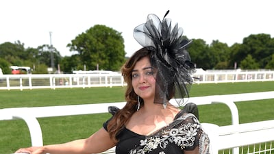 An attendee in a black sari with matching fascinator.
