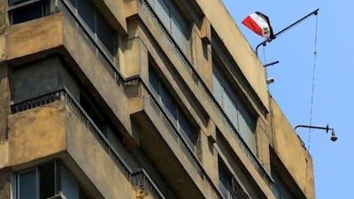 An Egyptian flag flutters over the Israeli embassy in Cairo Sunday. A protester became a hero to the Egyptians outside the embassy and many more online by hauling down the Israeli flag replacing it with an Egyptian one.
