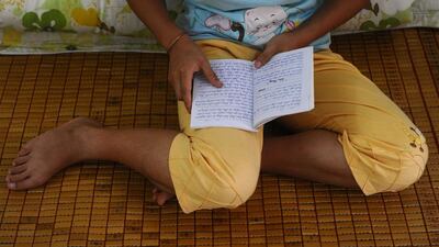 Kiab, a H’mong ethnic girl reads her diary at a government-run centre for trafficked women in the northern Vietnamese city of Lao Cai. Her brother sold her to a Chinese family as a bride when she turned 16. Hoang Dinh Nam / AFP / May 9, 2014
