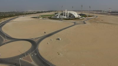 A before shot of the grass fields surrounding the main arena at Zayed Cricket Stadium.