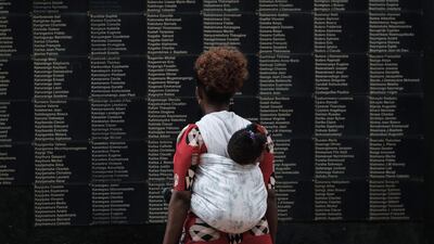 A woman carrying her child looks at the wall of victims' names as Rwanda marks the 25th Commemoration of the 1994 Genocide at the Kigali Genocide Memorial in Kigali, Rwanda, on April 8, 2019.AFP