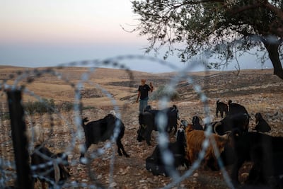 A masked Israeli settler stands near the Kaabneh Bedouin community, east of Taybeh, northeast of Ramallah. AFP