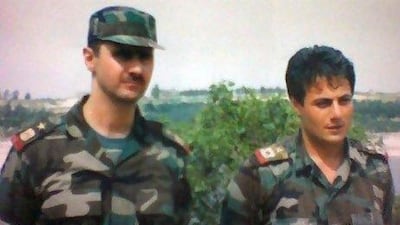 An undated handout file photo in an undisclosed location in Syria shows Syrian General Munaf Tlass, right, with Syrian President Bashar Al Assad.