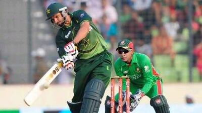 Pakistan's batsman Shahid Afridi, left, plays a shot as the Bangladeshi cricket captain Mushfiqur Rahim (R) looks during the one day international (ODI) Asia Cup cricket final match between Bangladesh and Pakistan at the Sher-e-Bangla National Cricket Stadium in Dhaka on March 22, 2012. AFP PHOTO/