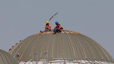 Workers take a break on the dome of a mosque under construction in Istanbul, Monday. The mosque in the historic Taksim square of central Istanbul which began to take shape in 2017, is expected to open for prayer later this year. AP Photo