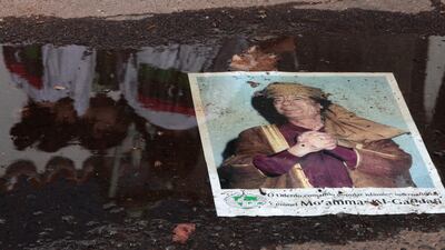** CORRECTS DAY TO MONDAY ** - A sign depicting Libya's leader Moammar Gadhafi lies on a puddle outside the Libyan embassy in Brasilia, Brazil, Monday, Aug. 22, 2011. A group of Libyans residents in Brazil, who are against Gadhafi's regime, entered the Libyan Embassy in Brasilia and intend to stay there until Gadhafi's deposition is announced. (AP Photo/Eraldo Peres) *** Local Caption *** CORRECTION Brazil Libya.JPEG-06756.jpg