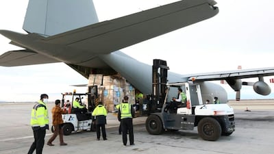A handout picture released by the World Health Organization (WHO) shows labourers unloading medical equipment and coronavirus testing kits provided by the World Health Organisation, from a United Arab Emirates military transport plane upon their arrival in Iran. AFP