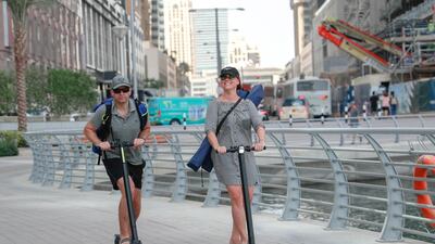 Marina residents scoot around the pedestrianised district on the electric rides. Riders are often seen without helmets. Victor Besa / The National