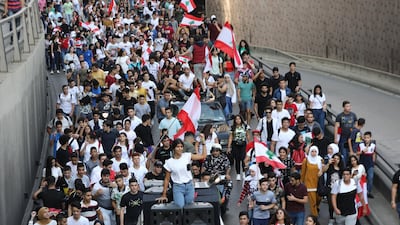 Lebanese students wave the national flag during a demonstration in the capital Beirut on November 9, 2019, as protesters keep up their three-week-long movement against a political class regarded as incompetent and corrupt. / AFP / ANWAR AMRO