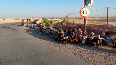 Fleeing Afghan soldiers sit at a bridge next to the Tajikistan-Afghanistan border in Tajikistan. AP