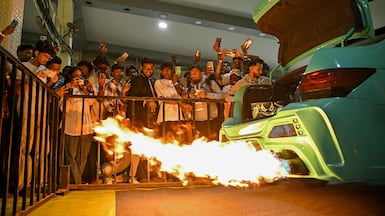 Visitors watch the exhaust of a modified Honda City during the International Autoshow 2025 in Bengaluru, India. AFP