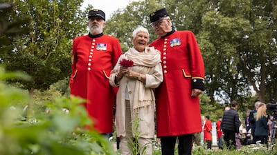 Dame Judi Dench stands with Chelsea pensioners on the RHS Queen's Green Canopy Garden. Getty Images