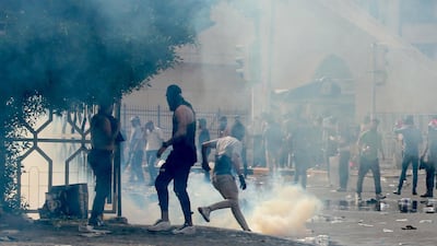 Iraqi protesters run for cover amid tear gas fired by policemen during a demonstration at Tahrir Square, central Baghdad. EPA