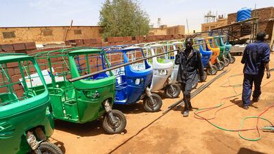 Workers assemble electric tuk-tuks at al-Shehab factory in the Sudanese capital's northern district of Khartoum-Bahri, on April 19, 2022. - In Sudan, three-wheeler vehicles -- tuk-tuk rickshaws for passengers, and motorbike tricycles with a trailer attached for carrying goods -- have long been a popular and affordable transport. But with the country gripped by a dire economic crisis made worse by political unrest following a military coup last October, the cost of running petrol-oil engines has soared. (Photo by ASHRAF SHAZLY / AFP)