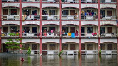 Flood-affected people take shelter inside a school building in Daganbhuiyan, Bangladesh, as they wait for the water to subside on August 25. AFP