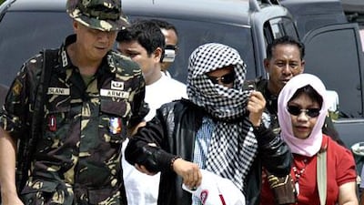 Andal Ampatuan, centre, is escorted by military personnel to a helicopter after he surrendered to authorities in Sharif Aguak, province of Maguindanao on November 26, 2009.