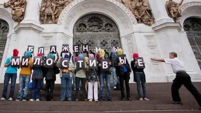 Pussy Riot supporters hold letters saying, 'The merciful are blissful', as they participate in a flash mob near the Christ the Savior Cathedral in Moscow.