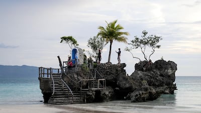 People pose for pictures on the Boracay Grotto also known as 'Willy's Rock'.