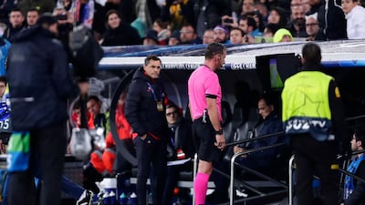 Referee Artur Dias watches the VAR monitor and then reverse his decision. AP