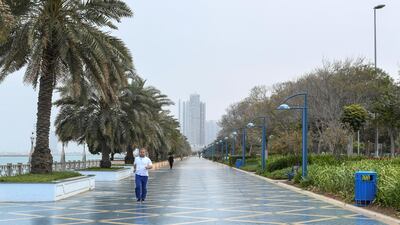 A man jogs in the Corniche during a slight rain early Friday morning. Khushnum Bhandari for The National
