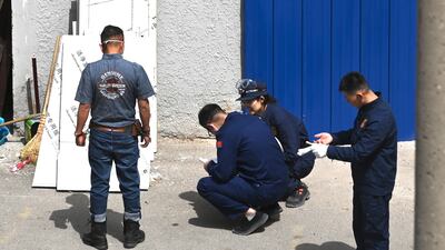 Investigators work outside the hospital after a fire broke out a day earlier. AFP