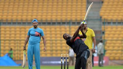 Usain Bolt, right, hits a six as Yuvraj Singh looks on during a practice session prior to the match on Tuesday, a four-over exhibition that was played at Chinnaswamy Stadium in Baglore. Majunath Kiran / AFP