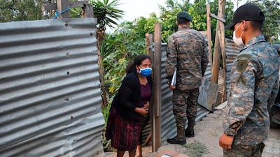 Guatemalan soldiers distribute boxes with food supplies at Las Brisas del Lago neighbourhood during a partial curfew ordered by the government, in Guatemala City. AFP