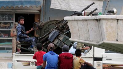 A Turkey-backed Syrian rebel fighter sits on the back of a truck mounted with a weapon in the border town of Tal Abyad, Syria, October 16, 2019. REUTERS/Khalil Ashawi
