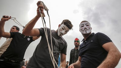 Palestinians protesters prepare their slingshots during clashes after Friday protests near the border with Israel in eastern Gaza City. Mohammed Saber / EPA