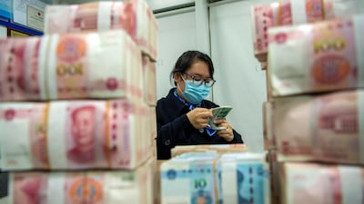 A clerk counts renminbi banknotes in Hai'an city in eastern China's Jiangsu province. AP