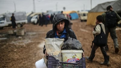 A child fleeing from Aleppo arrives with meagre belongings at the Turkish border crossing. (Bulent Kilic / AFP)