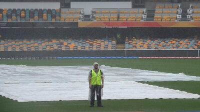 A groundsman stands on the edge of the square as rain prevents play between Australia and Bangladesh at the Gabba in Brsibane on February 21. Dave Hunt / EPA