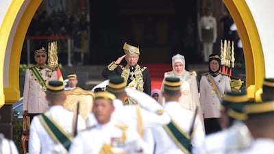 Malaysia's new King Sultan Abdullah and Queen Tunku Azizah, center right, inspect the royal guard. Malaysia Information Ministry via AP