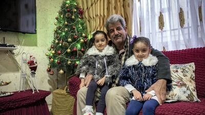 Louis Khno with his granddaughters Alina, left, and Angelina at his home in Qaraqosh, Iraq, on December 20, 2017. Campbell MacDiarmid