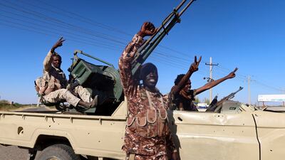 Sudanese army soldiers celebrate after entering Wad Medani on Sunday. Reuters