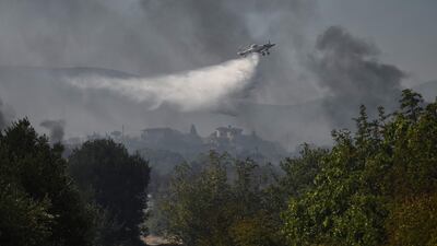 A plane sprays water as it flies over Dialekto village near Kavala, northern Greece. AFP